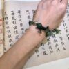 Greeting bracelet from EBIG Jewel on wrist held against writing