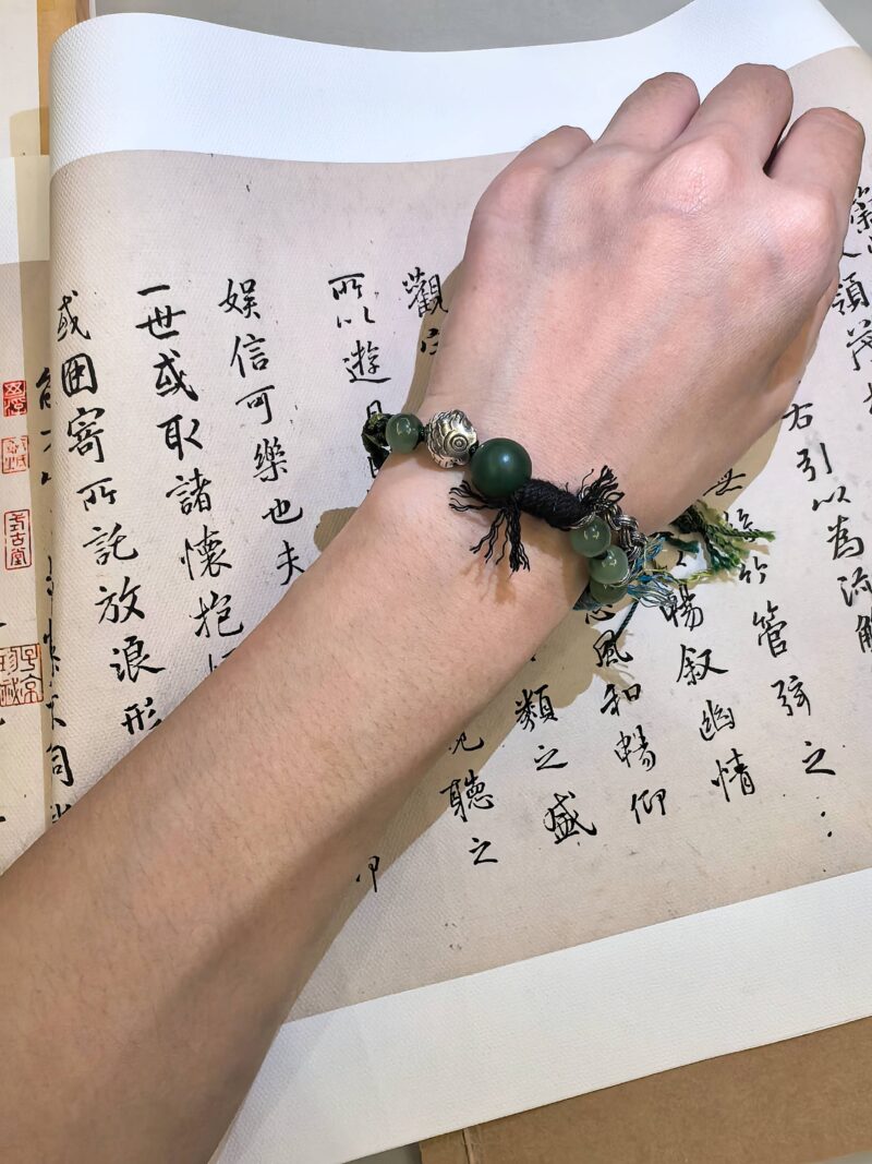 Greeting bracelet from EBIG Jewel on wrist held against writing