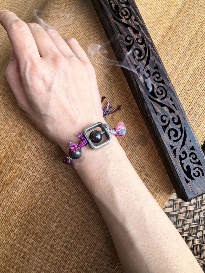 Brilliance bracelet from EBIG Jewel with incense being worn on wrist.